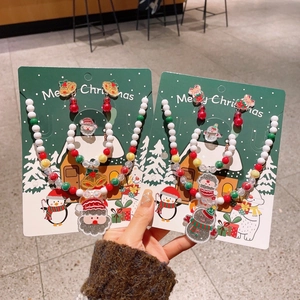 Dettagli di collane e braccialetti natalizi con ciondoli a forma di Babbo Natale