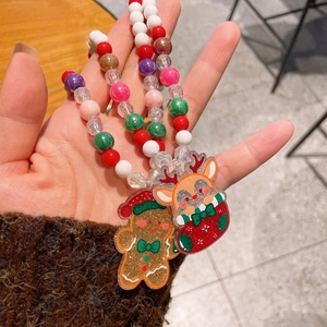 Dettaglio della collana natalizia con perline e ciondoli glitterati a forma di renna e omino