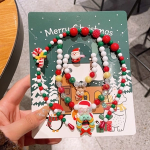 Set di gioielli natalizi per bambini con perline e ciondoli a tema su cartoncino