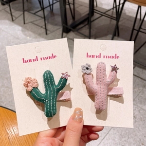 Détail de pinces à cheveux cactus en tricot avec fleurs au crochet et paillettes sur carte