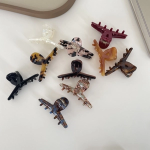 Flat lay of acetate hair claw clips in tortoiseshell and marble patterns showing details