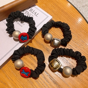 Detail view of 4-piece black elastic hair scrunchies with metal beads and puppy charms