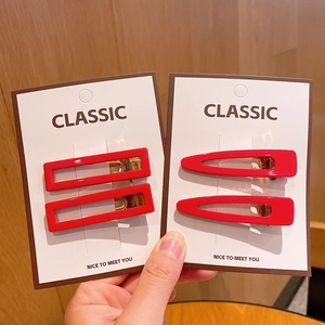 Red acrylic teardrop and square hair clips set with gold metal clasp on card