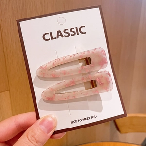 Detail of pink floral acrylic teardrop hair clips set on a classic display card