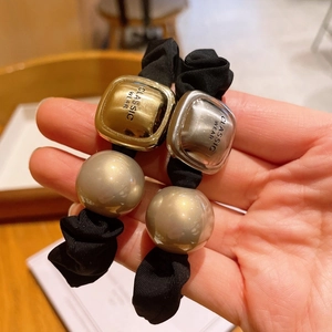 Classic scrunchies with metallic sliders and large beige pearls for elegant hairstyling