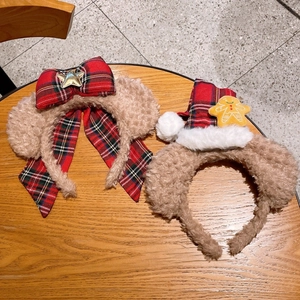 Détail de serre-têtes de Noël en peluche avec nœud écossais et figurine de bonhomme en pain d'épice