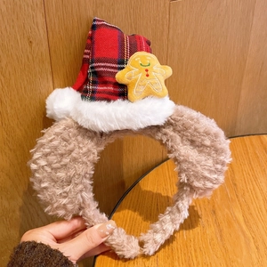 Détail d'un serre-tête de Noël en peluche avec bonnet à carreaux et figurine pain d'épice