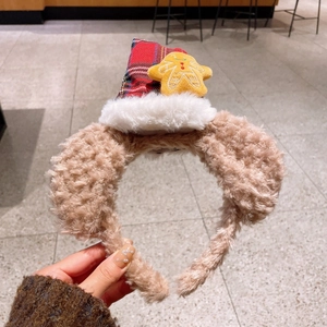 Détail d'un serre-tête de Noël avec oreilles en peluche et chapeau à carreaux rouge festif