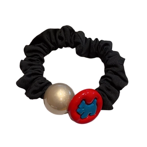 Elegant black scrunchie with cream bead and red charm featuring a blue dog motif