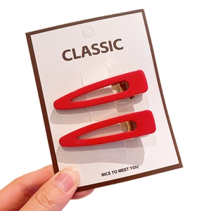 Set of two glossy red rectangular acrylic hair clips on a classic display card