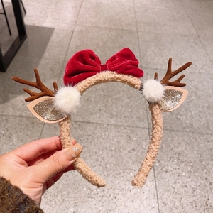 Détail du serre-tête de Noël avec nœud en velours rouge, bois de cerf et paillettes