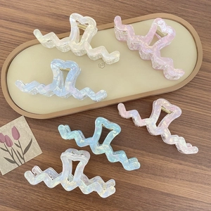 Set of 6 iridescent wave hair claw clips for women with pearl finish on wooden background