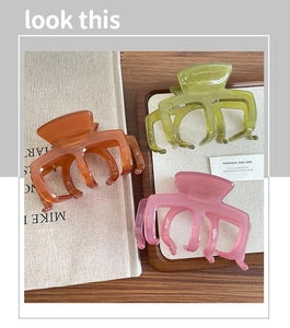 Dettaglio di tre mollette per capelli color gelatina con logo France Handmade inciso