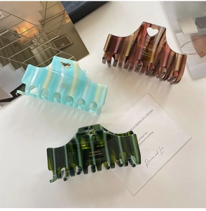 Close-up of heart-shaped large acetate hair claws with striped and tortoiseshell patterns