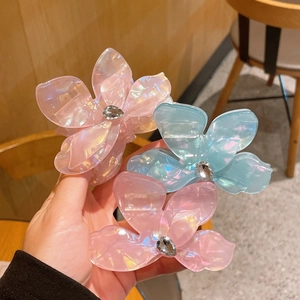 Pinces à cheveux fleurs de bougainvillier irisées avec strass tenues en main