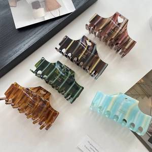 Five-piece large striped acetate hair claws in vintage colors with heart cutout details