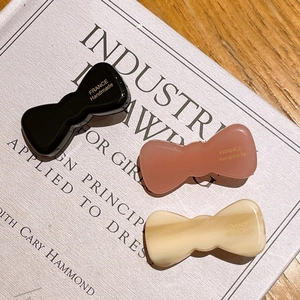 Three-piece set of acetate bow hair clips in black, brick red, and beige colors