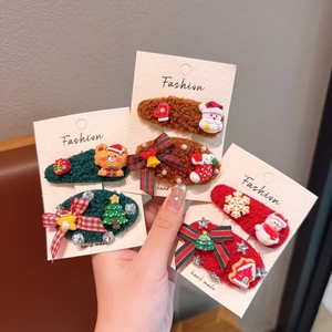 Détail de barrettes de Noël en peluche faites main avec motifs de Père Noël et de renne