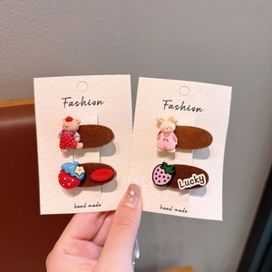 Détail de quatre barrettes floquées avec oursons, lapins et fraises en résine cartoon