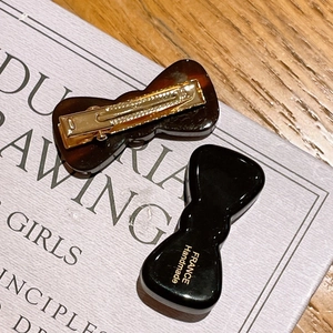 Detail of tortoise shell and black acetate bow hair clips with France Handmade text