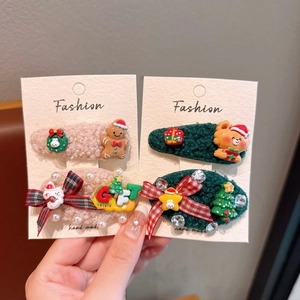 Détail de barrettes de Noël en peluche avec motifs bonhomme de pain d'épices et neige