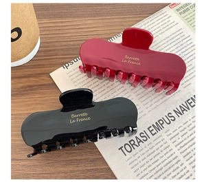 Detail of premium glossy square hair claws in black and deep wine red with gold lettering