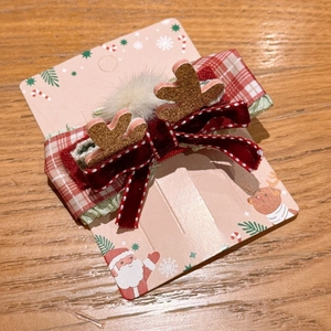 Detail of Christmas hair clip with red velvet bow and glittery reindeer antlers