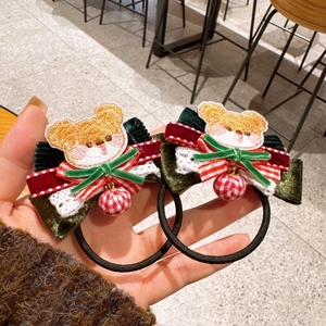 Detail of Christmas hair ties with bear embroidery, velvet bows and plaid decorative balls