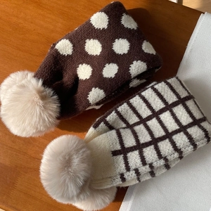 Détail d'écharpes d'hiver tricotées avec pois, carreaux et pompons doux en fausse fourrure