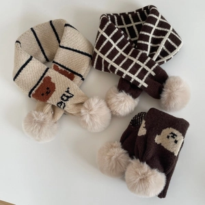 Détail d'écharpe tricotée enfant avec rayures beiges, motifs ours et pompons doux