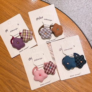 Lot de quatre chouchous en tissu fait main avec motifs à carreaux et unis sur table en bois