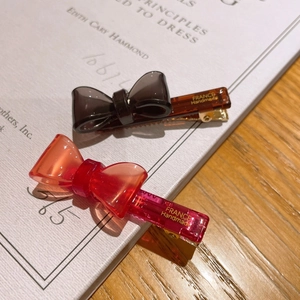 Detailed view of handmade acetate bow hair clips showing premium material and metal duckbill clip