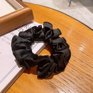 Elegant black satin scrunchie with high elasticity and pleated design for hair styling