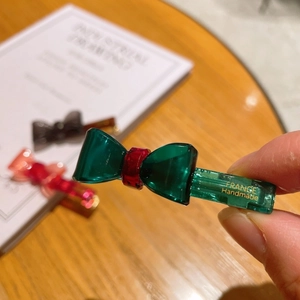 Detail of a handmade green acetate bow hair clip with translucent jelly finish