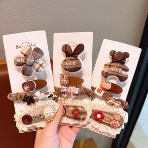 Detail of plaid fabric bows and resin animal charms on hair clips and scrunchies