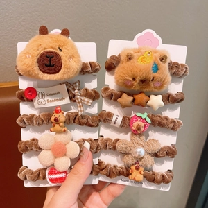 Detail von Plüsch-Capybara-Haargummis mit handgefertigten Etiketten auf Karten