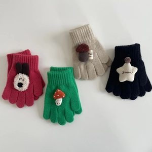 Flat lay of colorful knitted kids gloves with cute plush rabbit and mushroom charms