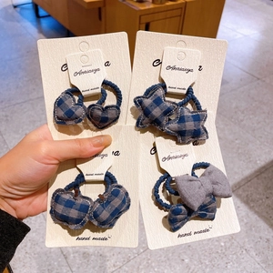 Detailed view of blue-gray plaid fabric hair ties in star, heart, and apple shapes