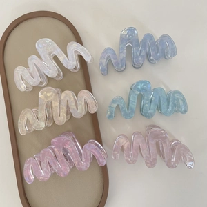 Set of wavy acetate hair claws in iridescent colors like pearl white and glacier blue
