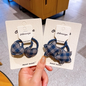 Detailed view of handmade blue-grey plaid heart and star hair ties on display cards