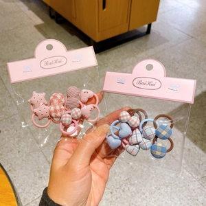 Close-up of cute checkered button flower hair ties set in pink and blue packaging