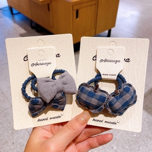Detail of handmade grey blue plaid heart and bow hair ties on display cards