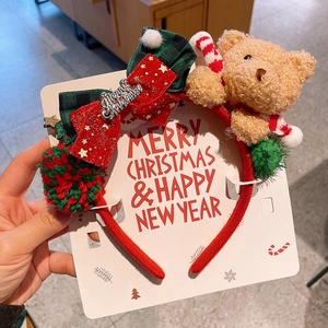 Detail of Christmas headband featuring plush bear, festive bow, and candy cane on display card