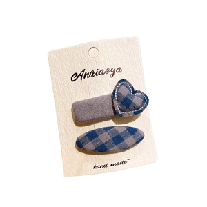 Blue and gray checkered hair clip set with heart and star shapes on a display card