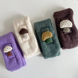 Detail of soft ribbed knit children's scarves in four colors with 3D mushroom patches