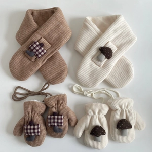 Detailed view of kids' thick knit scarf and mittens set with cute mushroom patches