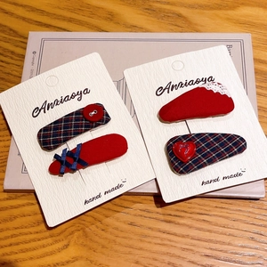 Détail des barrettes à cheveux à broderie florale rouge et bleu marine sur carte support
