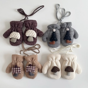 Detail of baby knitted mittens with neck strings in burgundy, grey, camel and off-white