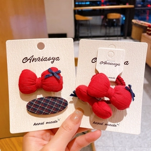 Gros plan sur les barrettes et élastiques faits main à fleurs rouges et nœuds à carreaux
