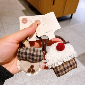 Gros plan sur chouchous faits main en tissu avec motifs de gland, gâteau et dentelle